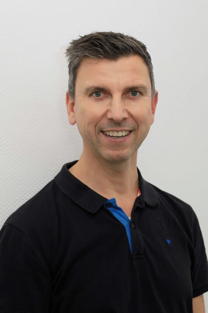 Freundlicher Arzt in Dorsten mit dunklem Polo.