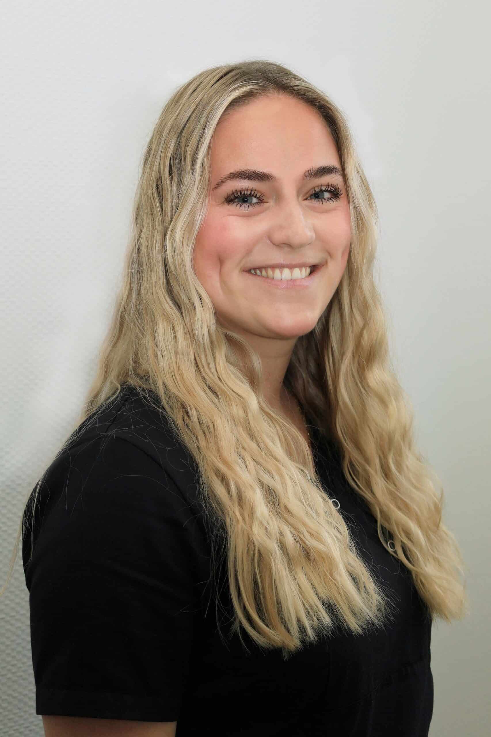 Freundliche Arzthelferin mit langem blondem Haar.